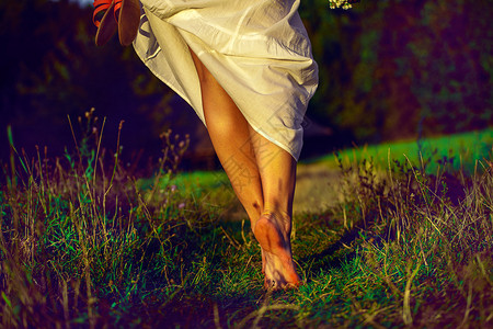 夏日穿长裙走在绿野中的女人图片