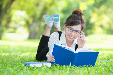 躺在草地上看书的亚洲学生图片