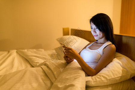 妇女用手机工作晚上躺图片