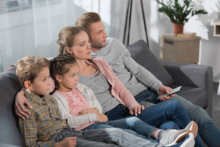 有孩子的家庭坐在沙发上看电视和看电视图片