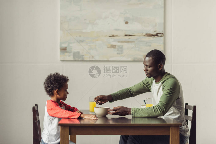 非洲裔美国父子吃早餐的侧视图图片