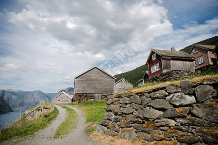 挪威FlamAurlandsfjord大山石墙农村道路和木制房屋图片