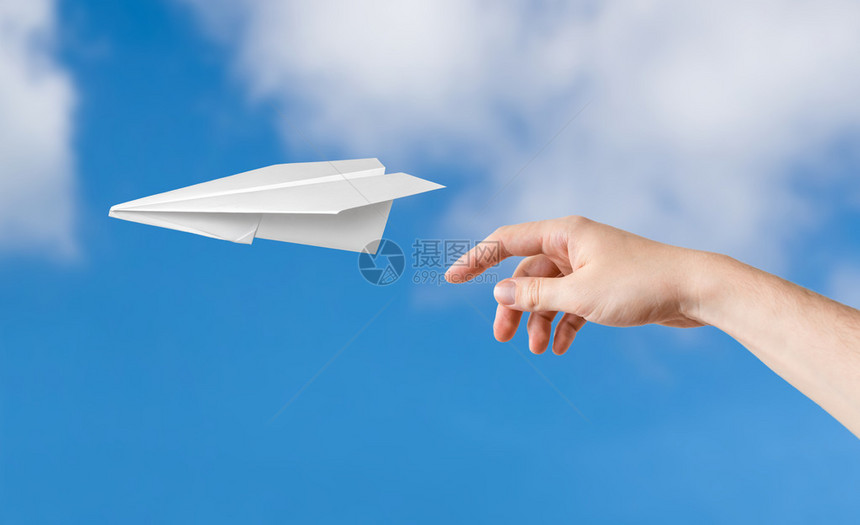 手扔折纸飞机背景上的蓝天图片