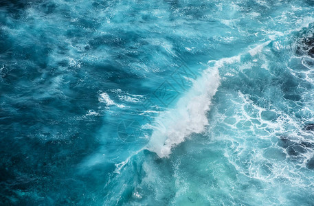 波浪和蔚蓝的水作为背景从海洋表面的高岩石查看自然夏季背景图片