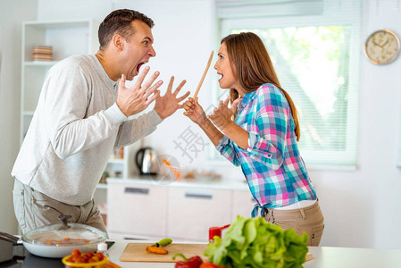 愤怒的情侣在家庭厨房争吵打图片