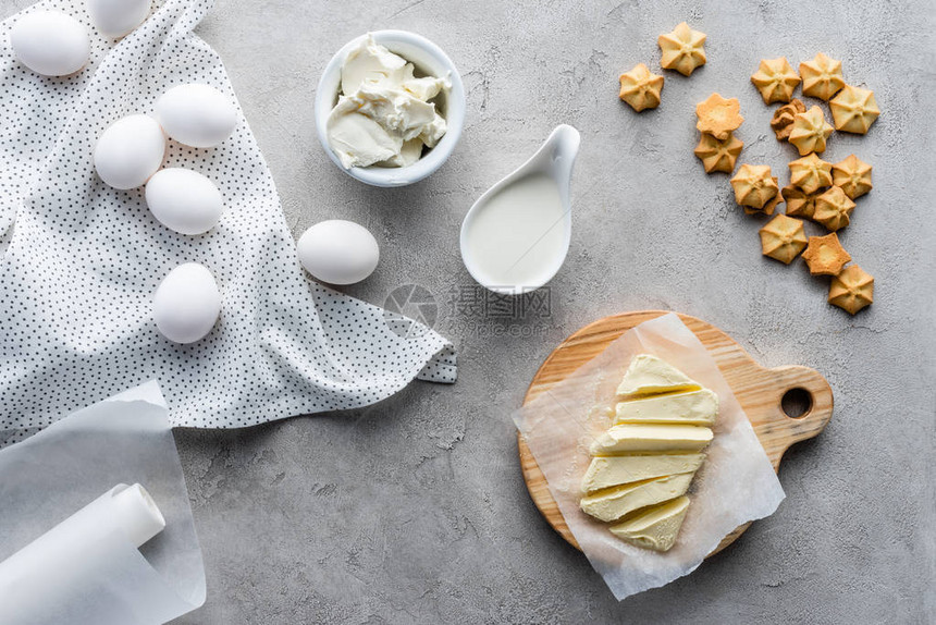 用切黄油酸奶油饼干和生鸡蛋成分在灰色表图片