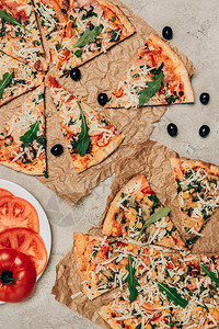 浅色背景下的热披萨和西红柿片背景图片