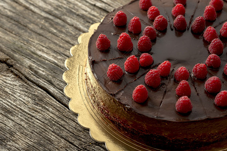 用覆盆子装饰的美味生巧克力蛋糕的俯视图邀请您沉迷于甜蜜的诱惑图片
