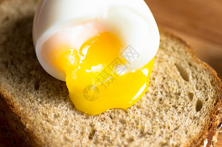 蛋黄从吐司上的煮鸡蛋流出图片