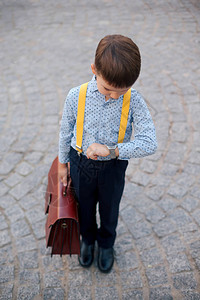 黑蓝裤子的男孩肖像婴儿蓝衬衫和黄色吊带图片
