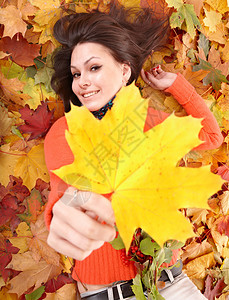 秋天树叶上的橙色女孩和黄色图片