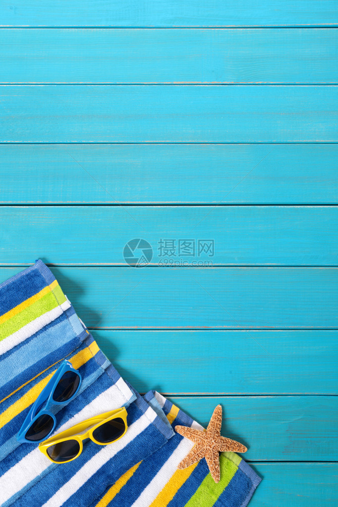 带条纹毛巾太阳镜海星和贝壳的海滩场景图片