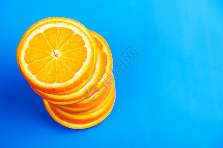 蓝色背景上的一堆切片橙子图片