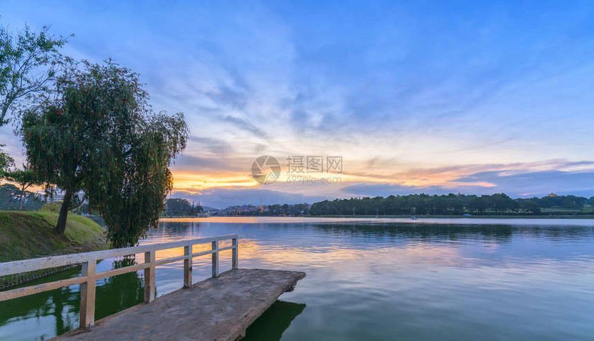 海岸湖的日落与戏剧天空使风景更加浪漫图片