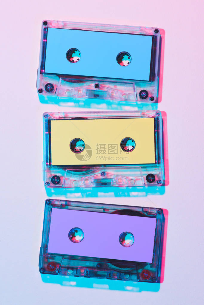 紫色背景上排列的彩色录音带的顶部视图图片