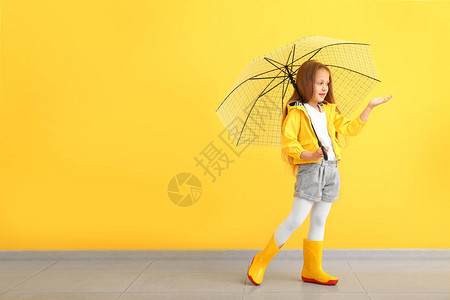 穿着秋衣和贴近彩色墙的雨伞图片