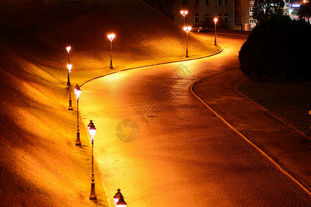 晚上在城市弯曲的道路夜街和黄灯图片