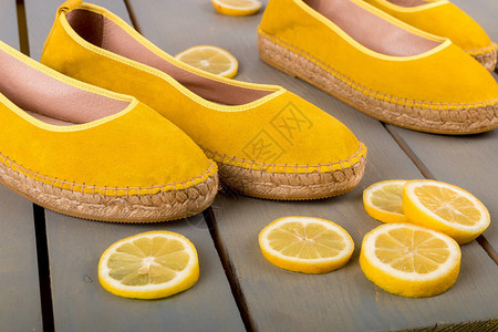 黄色埃斯帕德里尔鞋靠近木制背景图片