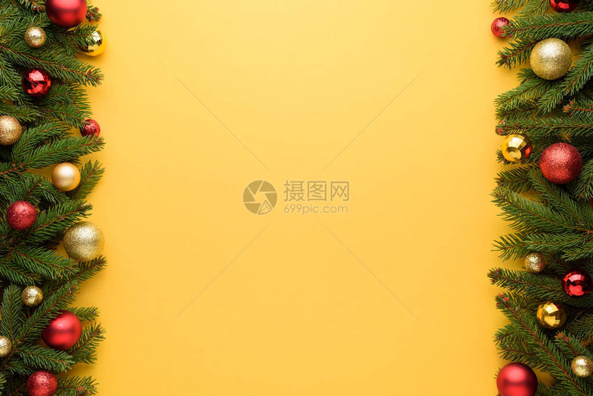 圣诞球和冷杉树枝的装饰边框圣诞快乐和设计的黄色背景复制促销空图片