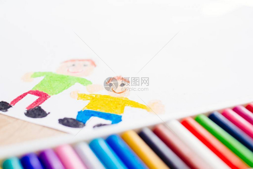五颜六色的蜡笔油蜡笔和儿童画的父亲和儿子图片