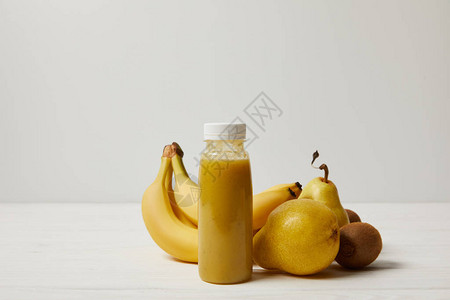 黄色冰沙配香蕉猕猴桃和白色背景的梨图片