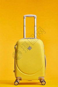 黄色旅行袋在橙色上隔背景图片