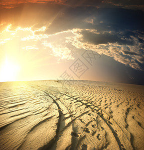 日落时分沙漠中的乡间小路图片