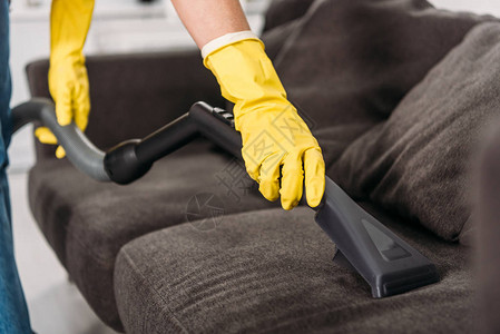 在用橡胶手套清洗沙发和吸尘器清洁工的橡皮手套中妇图片