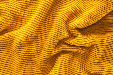 波浪黄色羊毛织物背景的特写视图图片
