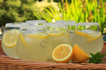 鲜榨柠檬水专注于前面的玻璃和柠檬图片