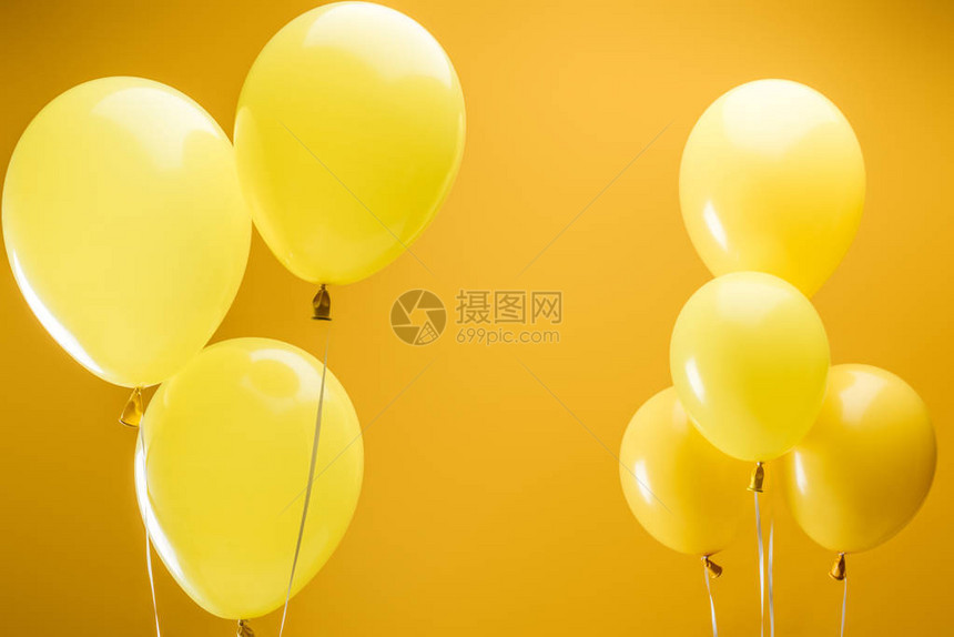 黄色背景上的节日明亮简约气球图片