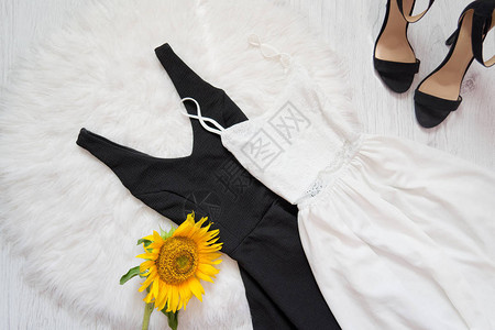 白色毛皮上的黑白衣服鞋子和向日葵时装概图片