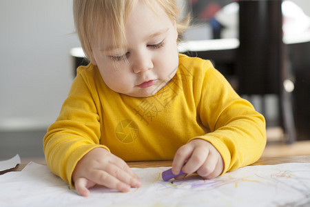 金发16个月的婴儿黄毛衣画白纸在家中图片