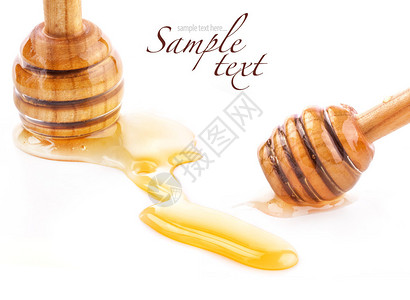 木制蜂蜜勺和蜂蜜滴在白色上分离图片