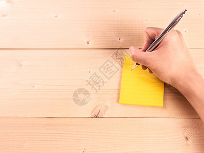 男人手在木桌上写便条图片