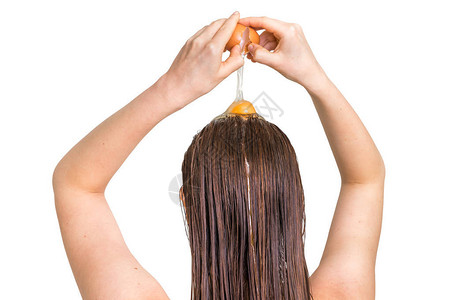 迷人的女人在头发上应用鸡蛋调制器孤背景图片