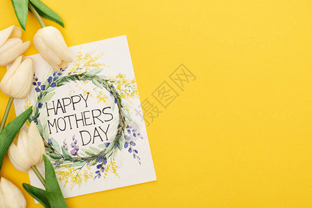 五颜六色的黄色背景上的春天郁金香和快乐母亲节背景图片