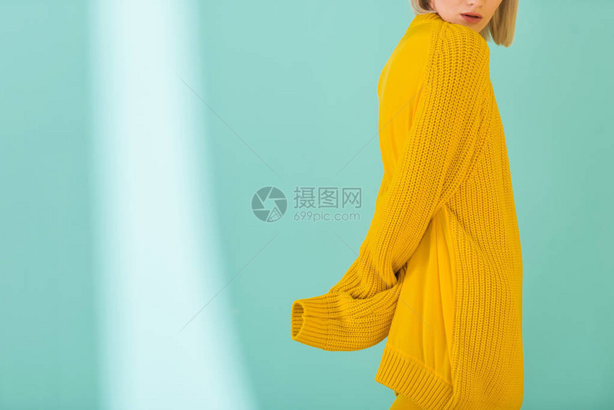 穿黄色毛衣穿着蓝色背景布满蓝色衣服的妇图片