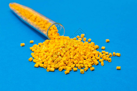 工业用颗粒中的塑料原蓝色背景上的黄色聚合物废聚乙烯和聚丙烯加工后的塑料颗粒聚合物BPAFREEPlas图片