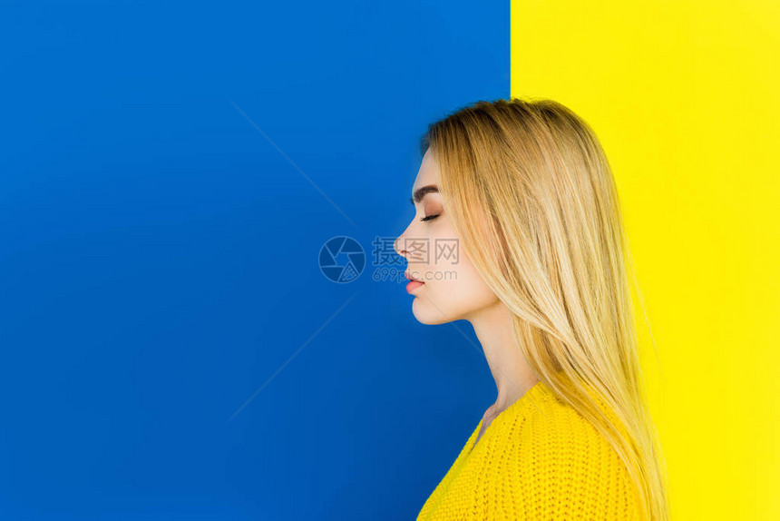 以蓝色和黄色背景与世隔绝的穿黄色衣服闭着眼睛图片