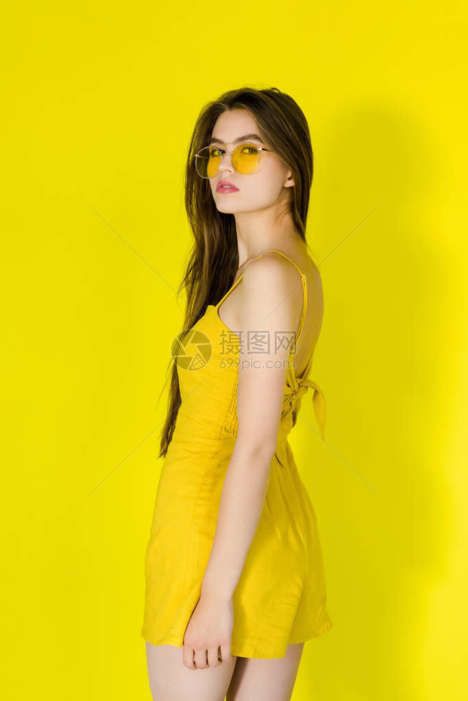 黄色礼服和太阳墨镜上披黄色背景图片