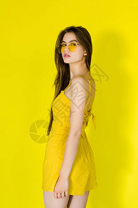 黄色礼服和太阳墨镜上披黄色背景图片