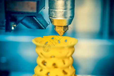 3D打印机从塑料人物特写中打印出来打印机在灰色平面上制作图片