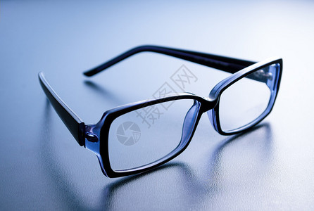 蓝色背景反射的角框眼镜背景图片