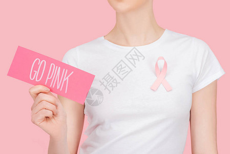 戴着粉红乳腺癌标志的女生手拿粉红色卡片图片