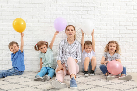 幼小可爱儿童幼儿教师和空气球在白砖图片