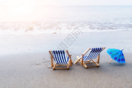 沙滩上的两把沙滩椅和一把小伞图片
