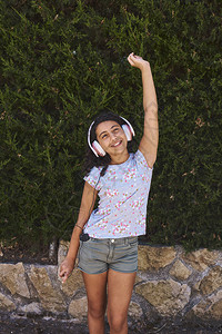 一个女孩跳跃着欢乐听用耳机的音乐图片
