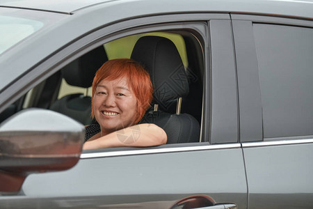 驾驶汽车的女士微笑地看向窗外图片
