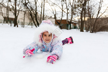 在白雪皑的冬季公园玩耍的快乐女孩图片
